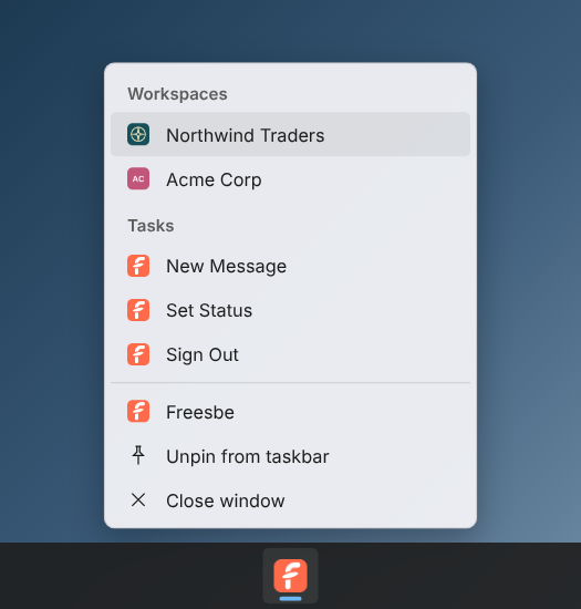 The Windows taskbar menu: Northwind Traders with its logo and Acme Corp with its initials under Workspaces, then New Message, Set Status and Sign Out